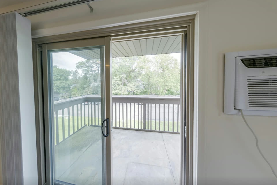 Sliding door opening onto the balcony, with a wall A/C unit